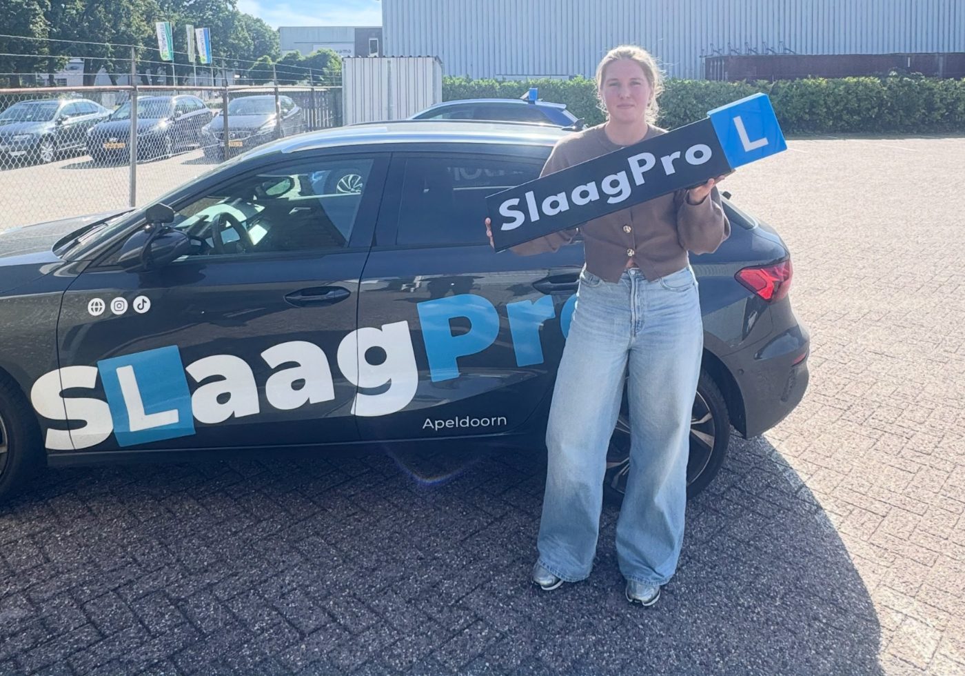 Leerling van SlaagPro met het L-bord bij de Audi lesauto